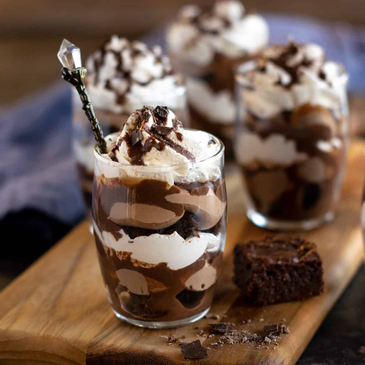 Eggless chocolate brownie mousse trifle dessert served in clear glasses.
